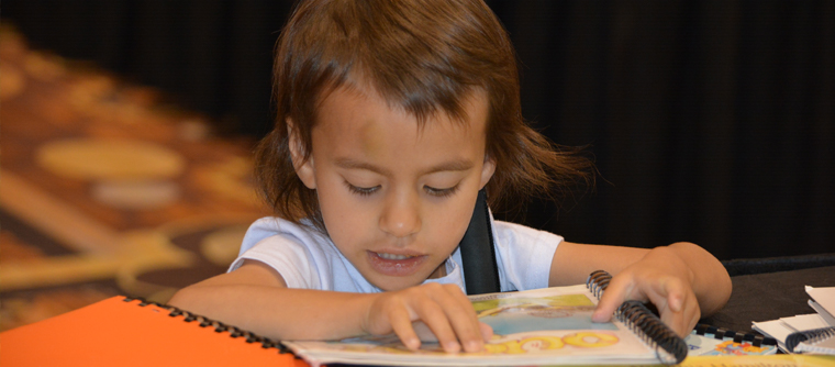 A young blind girl reading a Braille book